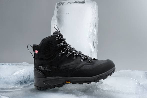 Schwarzer Winterboot auf eisigem Untegrund