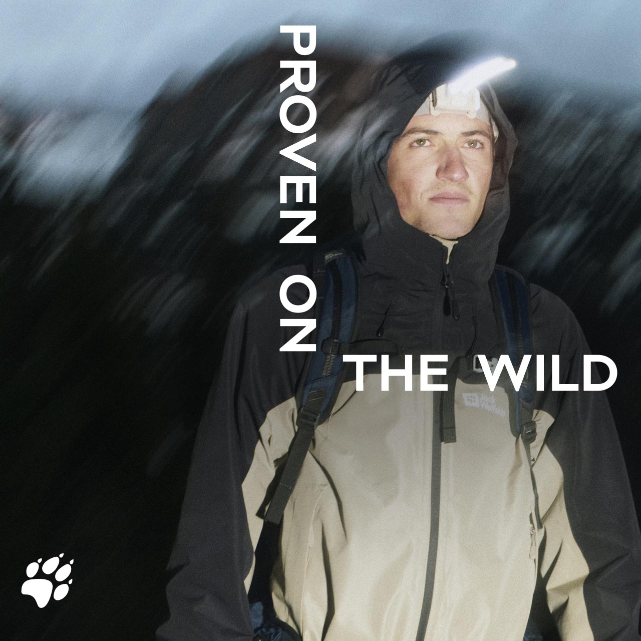 Une personne avec une veste à capuche est dans la nature la nuit et porte une lampe frontale. Le texte est le suivant : « Proven on the Wild »
