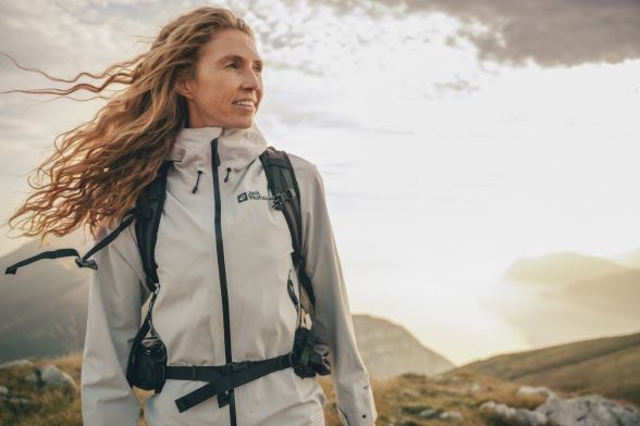 Une femme en tenue de randonnée printanière dans un paysage montagneux