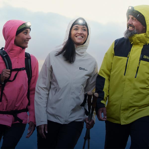 3 Personen wandern mit Blick zur Kamera