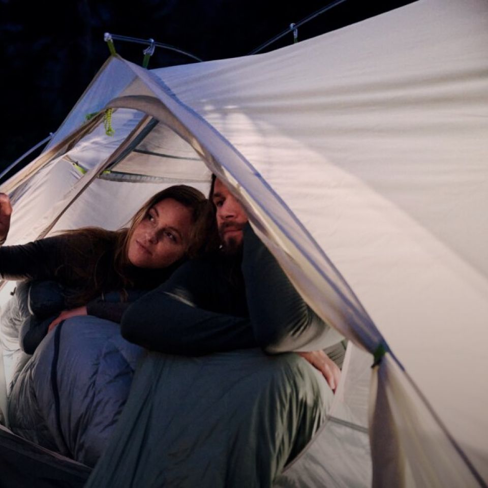 Une femme et un homme dans une tente à la nuit tombée