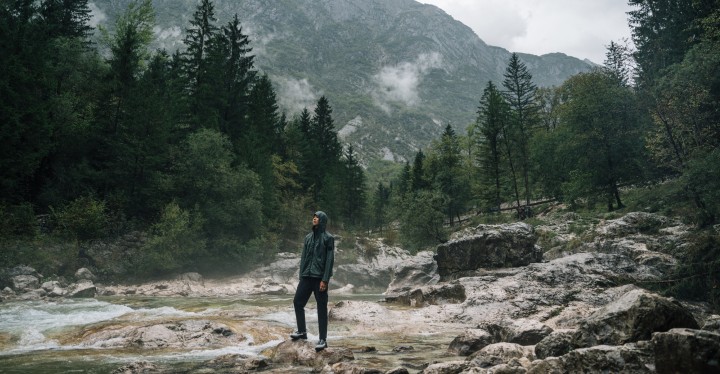 Un homme en tenue outdoor debout dans le brouillard d’un paysage de montagne