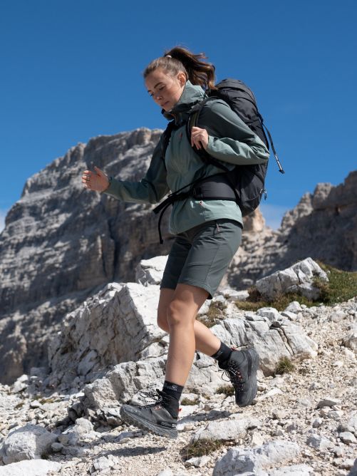 Un randonneur avec un grand sac à dos marchant en descente