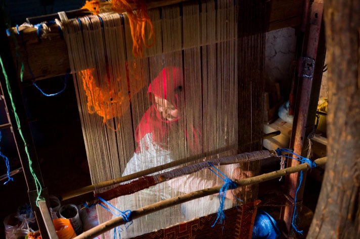 Une femme tissant un tapis