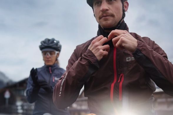 Gros plan frontal sur deux cyclistes dans un paysage de montagne brumeux