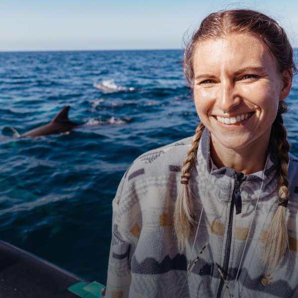 Margarita sur un bateau avec des dauphins en arrière-plan