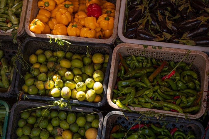 Paprika, Gurken, Limetten und Auberginen in grossen Kisten