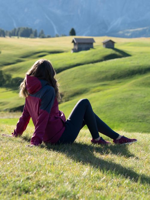 Eine Frau sitzt entspannt im Gras