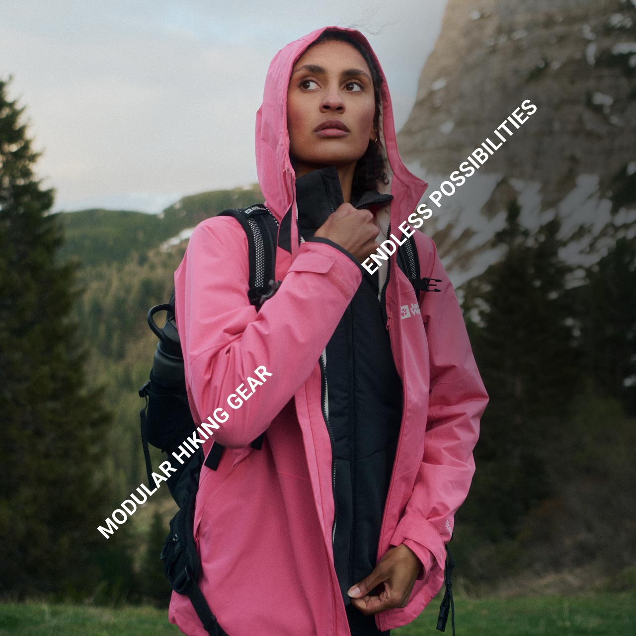 Une personne avec une veste rose est dans une forêt vallonnée et semble pensive. Le texte est le suivant : « Modular Hiking Gear » et « Endless Possibilities »