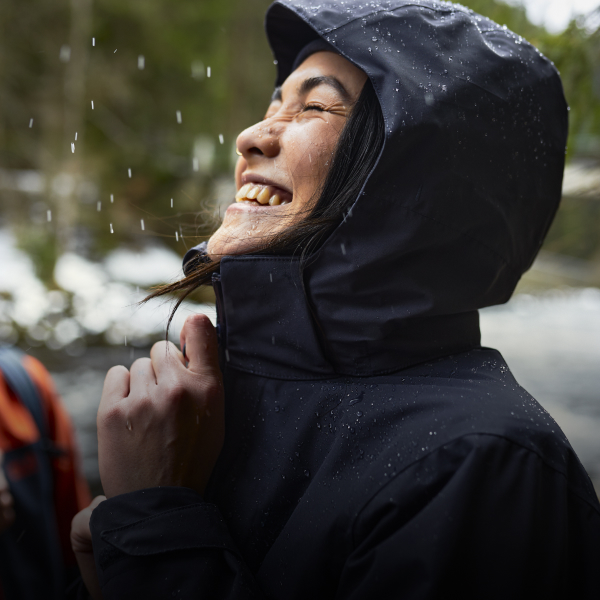 Frau mit wasserdichter Jacke im Regen
