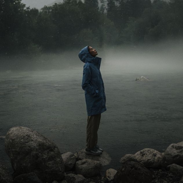 Frau steht im Regen