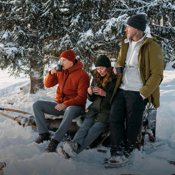 Trois personnes assises sur une luge dans la neige